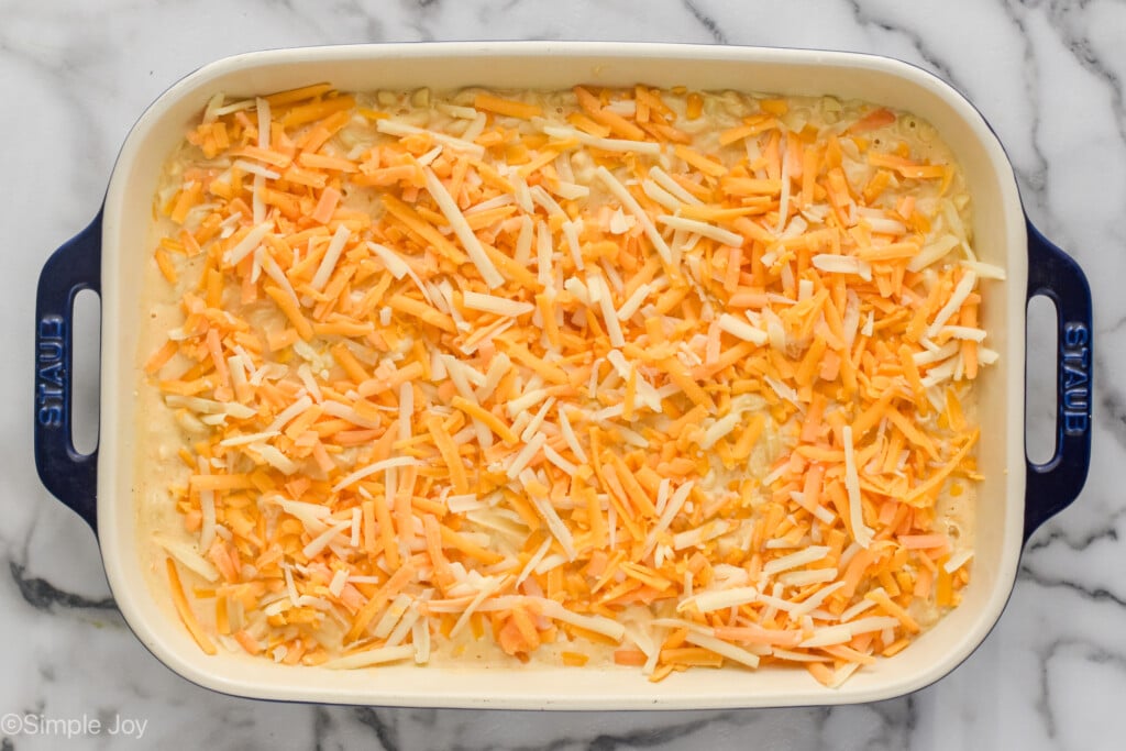 an overhead photo of Mac and Cheese in a casserole dish topped with more cheese ready to bake