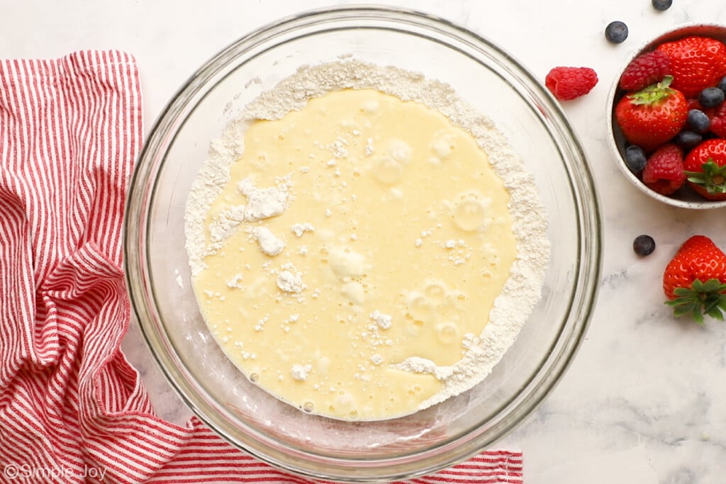 overhead of wet ingredients and dry ingredients coming together for waffles