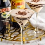 martini glass of Mudslide topped with chocolate shavings. Glass of mudslide, bottle of bailey's irish cream, and bottle of kahlua sitting in background - 9
