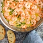 Pinterest graphic for Garlic butter shrimp. Image shows overhead of a skillet of Garlic butter shrimp with fresh parsley. Says "super easy Garlic butter shrimp simplejoy.com"