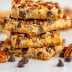 pinterest graphic a stack of magic cookie bars says, super easy seven layer bars simplejoy.com - 2