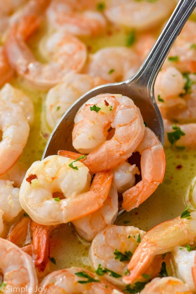 spoon holding Garlic butter shrimp in a skillet of Garlic butter shrimp - 5