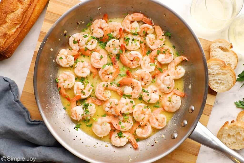 overhead of a skillet of garlic butter shrimp garnished with parsley