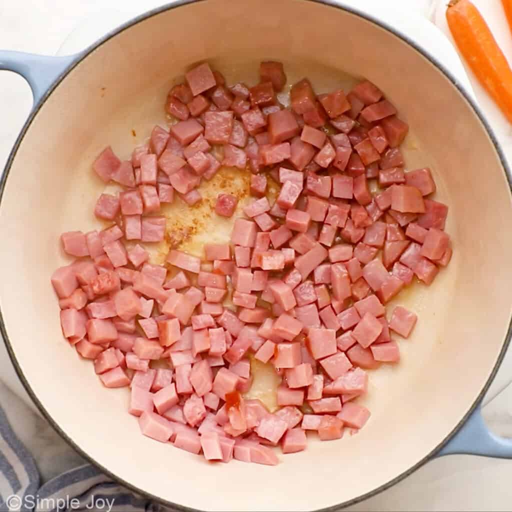 overhead of browning ham in a stock pot