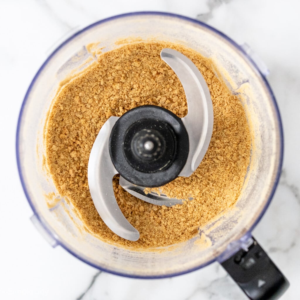 overhead of graham cracker crumbs in a food processor