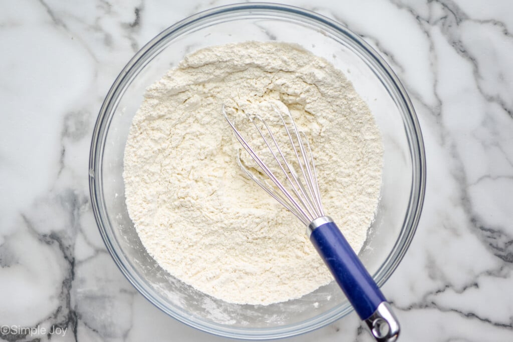 overhead of a bowl of flour with baking powder and salt to make sugar cookies