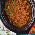 Pinterest graphic for Slow Cooker Taco Meat recipe. Image is overhead view of Slow Cooker Taco Meat recipe in a crock pot. Text says, "3 ingredient crockpot taco meat simplejoy.com."