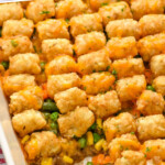 Pinterest graphic for tater tot casserole. Says "delicious easy tater tot casserole simplejoy.com" Image shows a baking dish of tater tot casserole