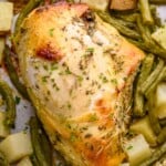 close up of a cooked cooked sheet pan chicken with potatoes and green beans around it - 10