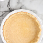 Pinterest graphic for Blind Bake Pie Crust recipe. Text says, "How to: Blind Bake Pie Crust simplejoy.com." Image is overhead view of Blind Bake Pie Crust after baking.