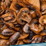 Pinterest graphic for Sautéed Mushrooms recipe. Image is close up view of Sautéed Mushrooms with a wooden spoon. Text says, "Sautéed Mushrooms simplejoy.com."