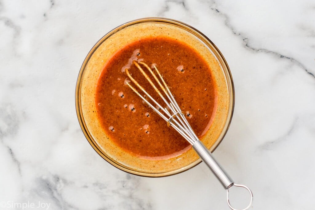 Overhead view of a mixing bowl of sauce with a whisk for Air Fryer Pork Tenderloin recipe.