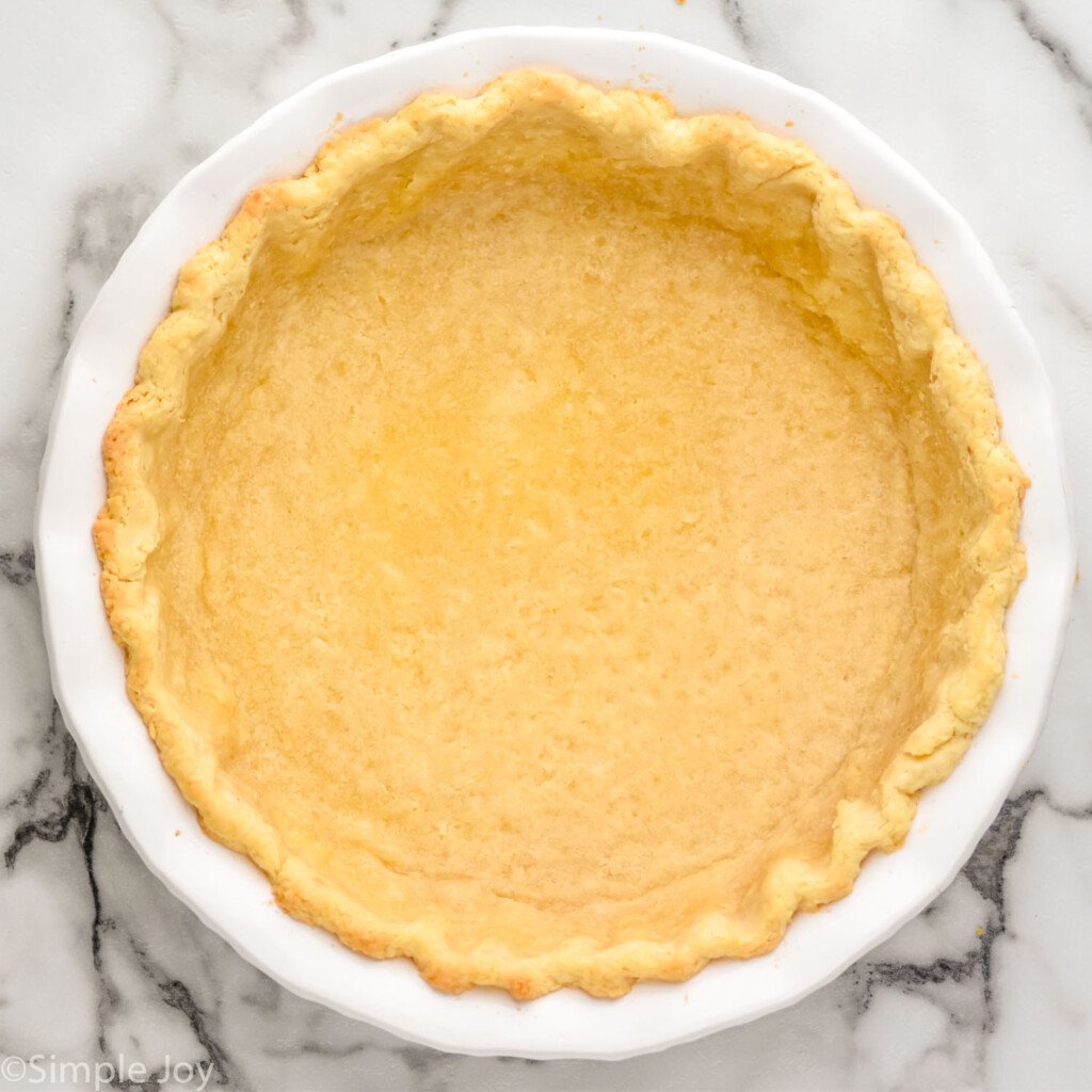 Overhead view of baked pie crust for Spinach Quiche recipe.