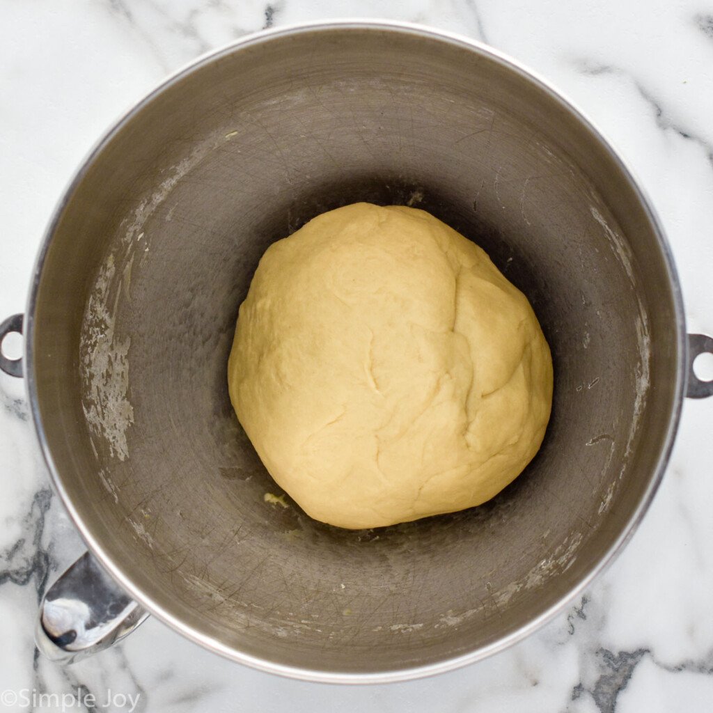 overhead of mixing bowl with cinnamon roll dough ball