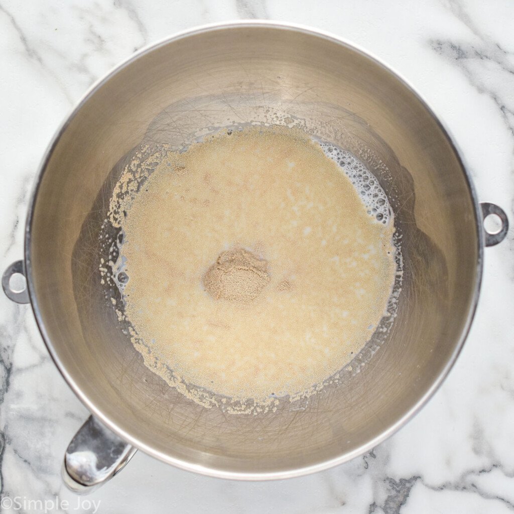 overhead of bowl of stand mixer with Homemade Cinnamon Rolls ingredients