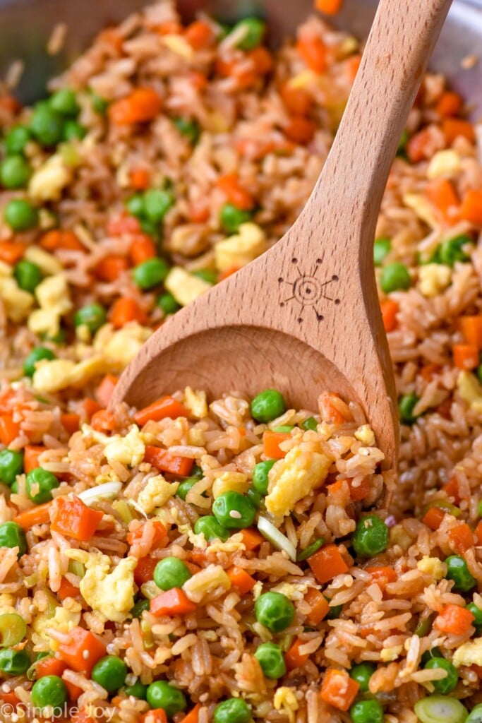 a wooden spoon dishing up some fried rice recipe