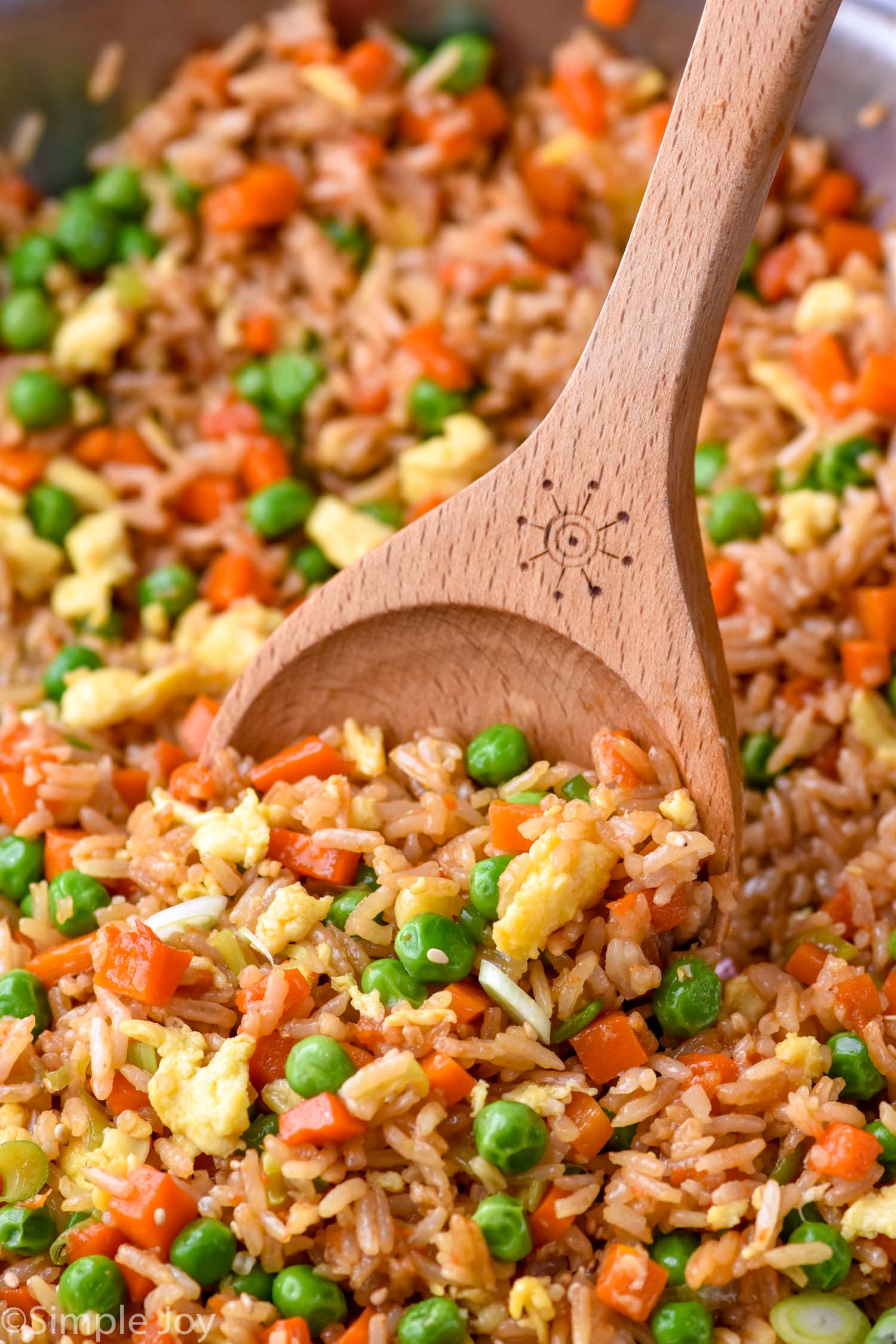 a wooden spoon dishing up some fried rice recipe