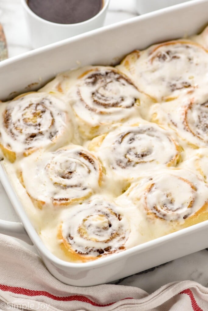 Baking dish of homemade cinnamon rolls topped with icing