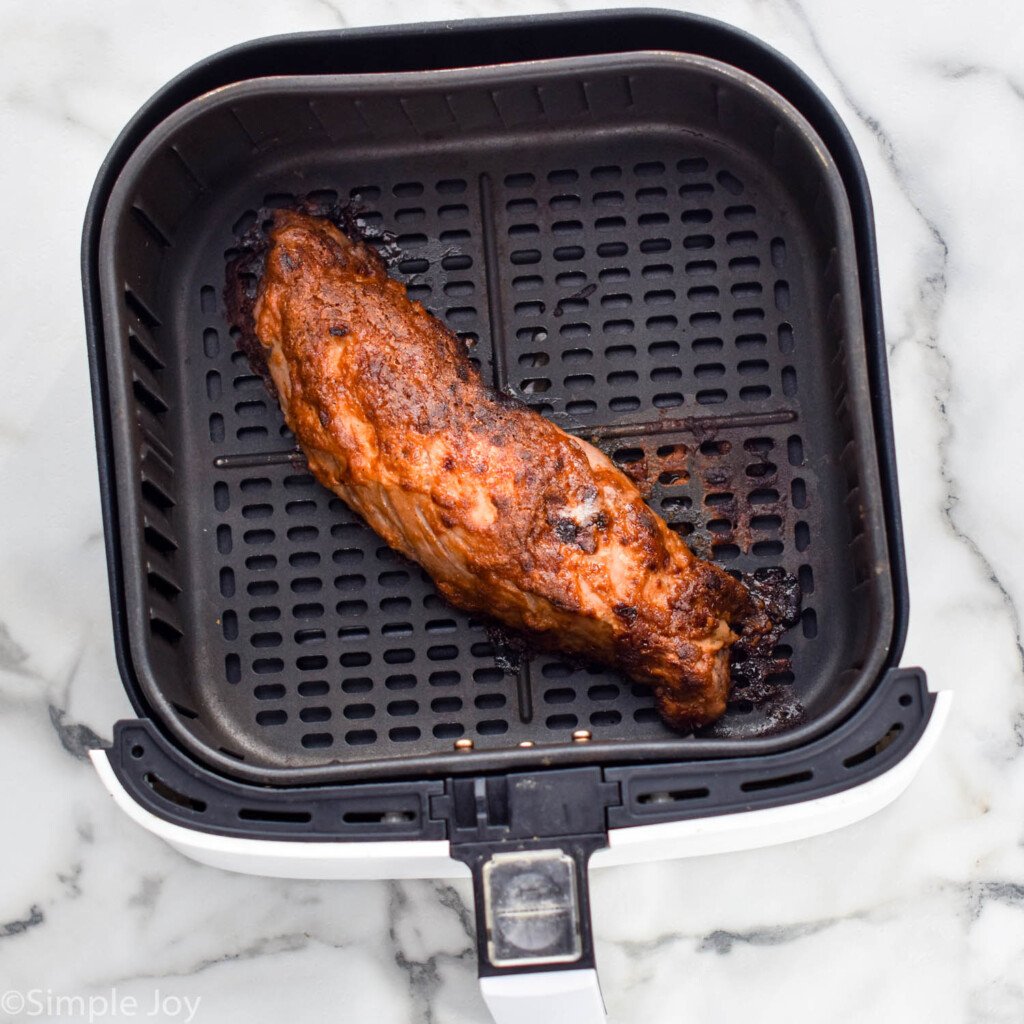 Overhead view of cooked Air Fryer Pork Tenderloin in an air fryer basket.