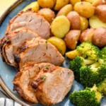 Slices of Air Fryer Pork Tenderloin served on a plate with potatoes and broccoli. - 9
