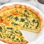 Spinach Quiche with one piece removed. Cups of coffee and bowl of berries beside. - 10