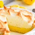 Pinterest graphic for Lemon Meringue Pie. Says "Lemon Meringue Pie simplejoy.com" Image shows a pie plate of Lemon Meringue Pie with lemon and lemon slices sitting in front and behind.