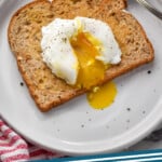 Pinterest graphic for Poached Eggs. Image shows a Poached Egg on a piece of toast with fork sitting beside. Says "Poached Eggs simplejoy.com"