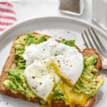 Pinterest graphic for Poached Eggs. Says "super easy Poached Eggs simplejoy.com" Image shows a poached egg with runny yoke on a piece of toast with mashed avocado