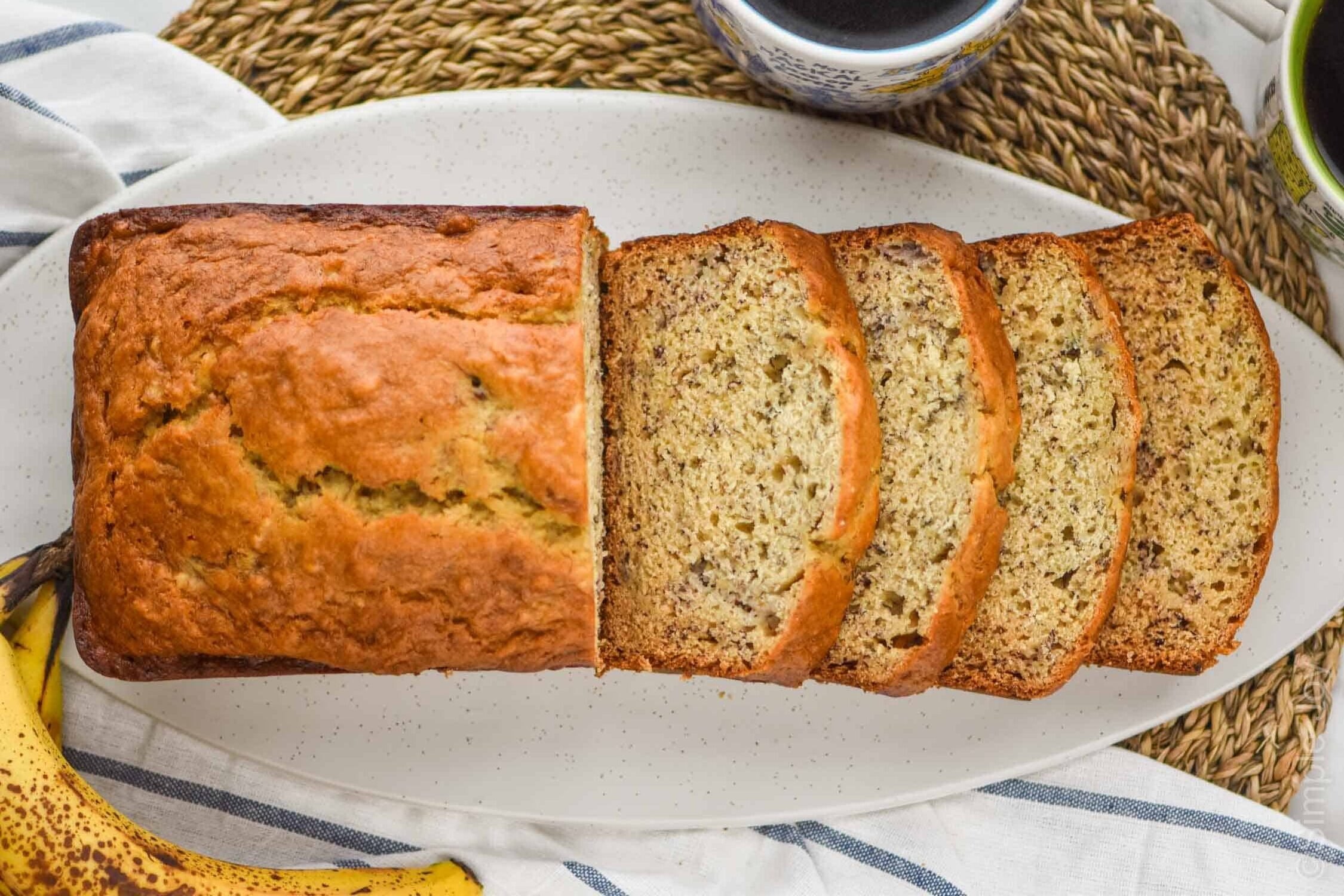 overhead view of banana bread recipe, the first half of the loaf has been sliced