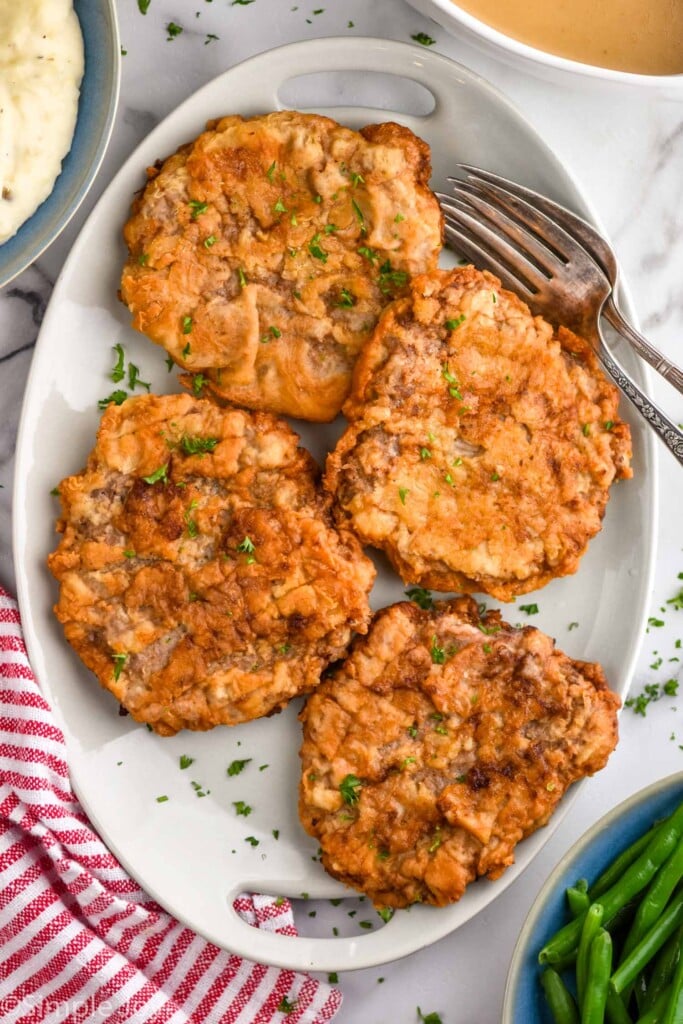 overhead of cooked Chicken Fried Steak with two forks for serving