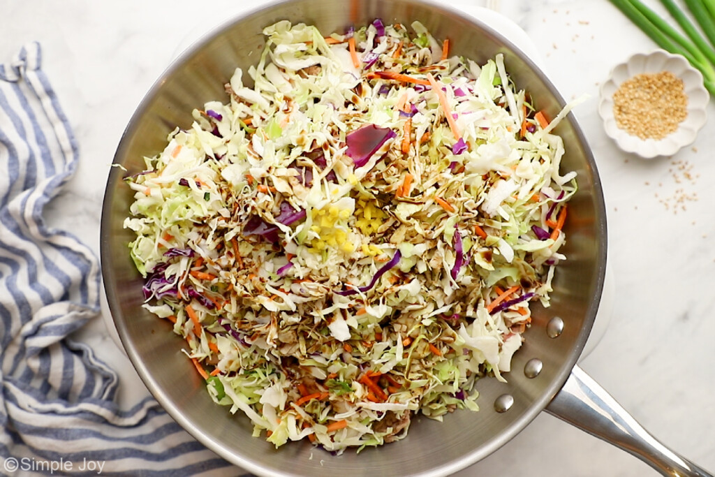 coleslaw being added to a skillet