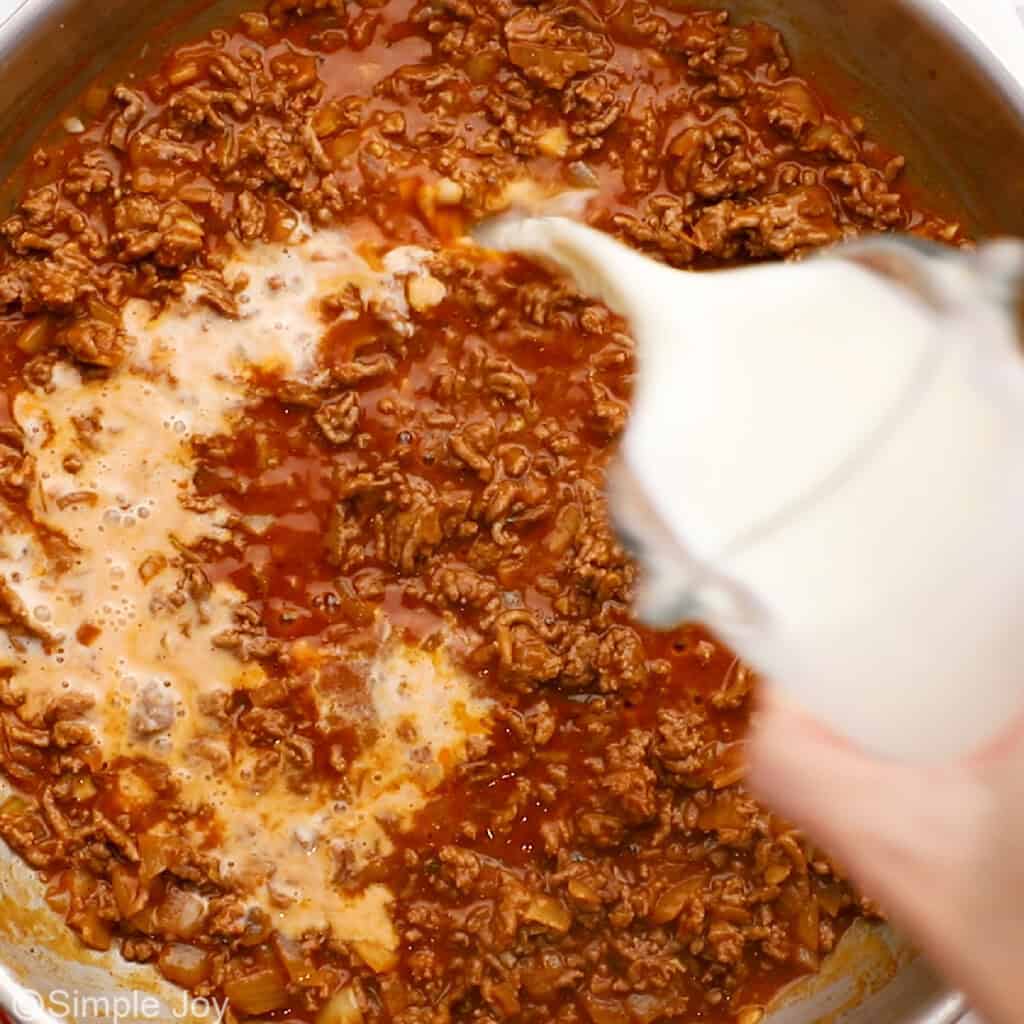 pouring milk into a skillet to make hamburger helper