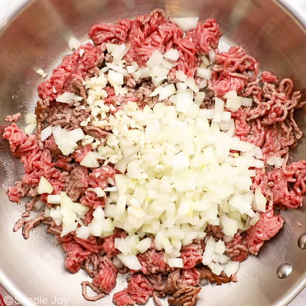 browned ground beef in a skillet with onion and garlic
