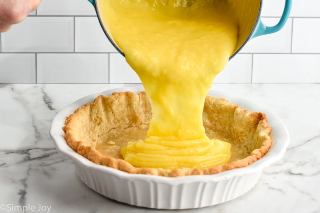 lemon filling being poured into a partially baked crust