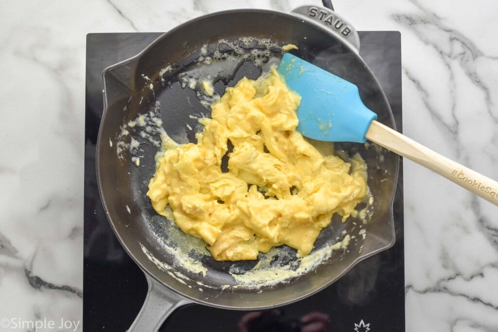 overhead of skillet of Scrambled Eggs with a spatula