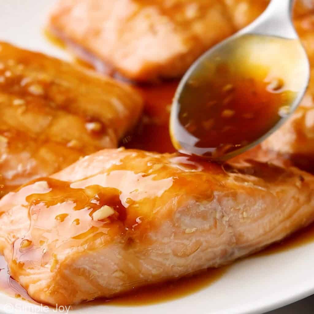 spooning teriyaki sauce over salmon