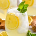 Limoncello Spritz garnished with lemon slice and mint leaves. Lemon slices and mint leaves beside.