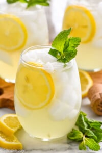 Limoncello Spritz garnished with lemon slice and mint leaves. Lemon slices and mint leaves beside.