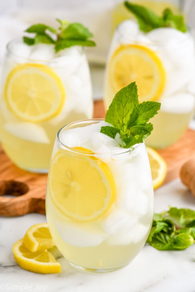 Limoncello Spritz garnished with lemon slice and fresh mint leaves. Lemon slices, mint leaves, and a cork on counter beside.