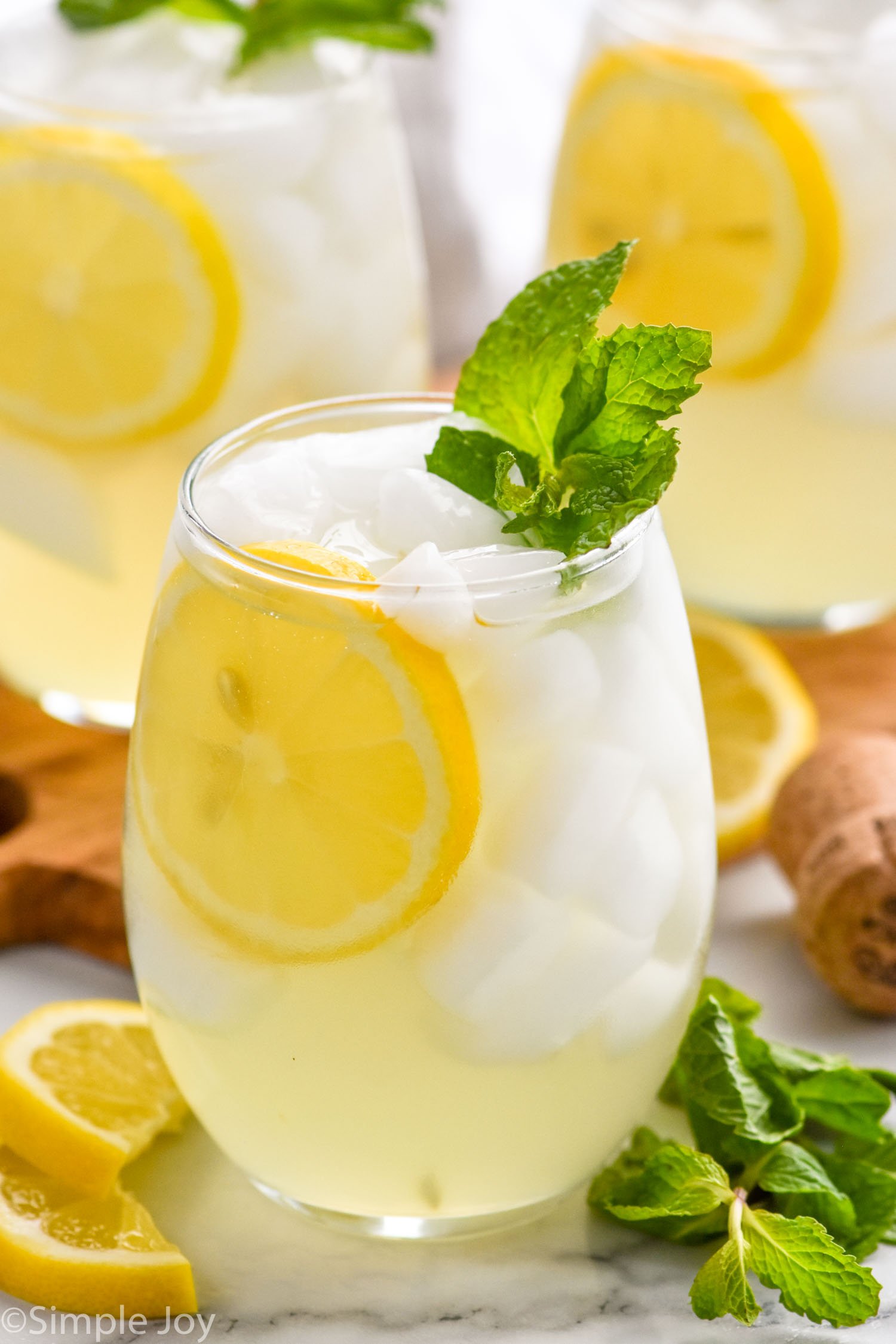 Limoncello Spritz garnished with lemon slice and mint leaves. Lemon slices and mint leaves beside.