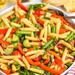 Bowl of Pasta Primavera with forks for serving. Bread and glasses of white wine beside. - 10