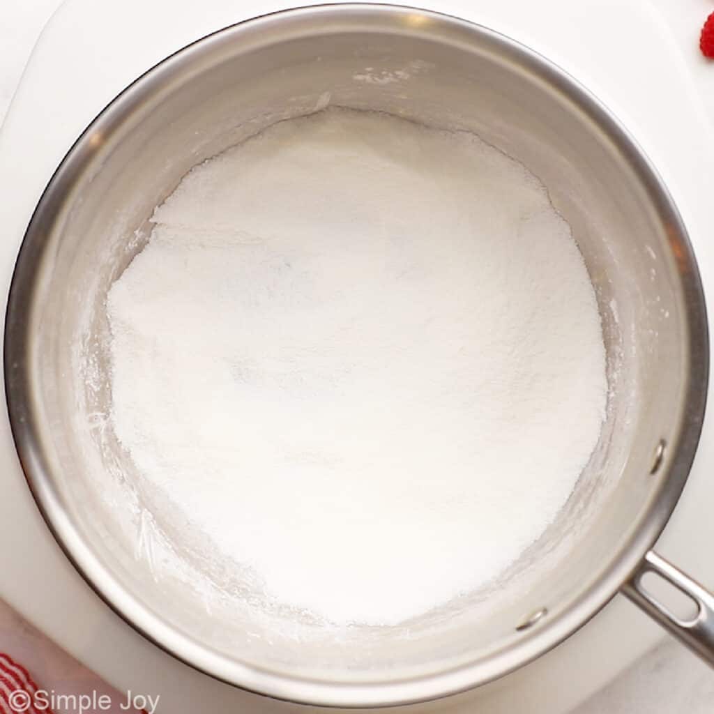 overhead of a saucepan with cornstarch, sugar, and salt whisked together in it