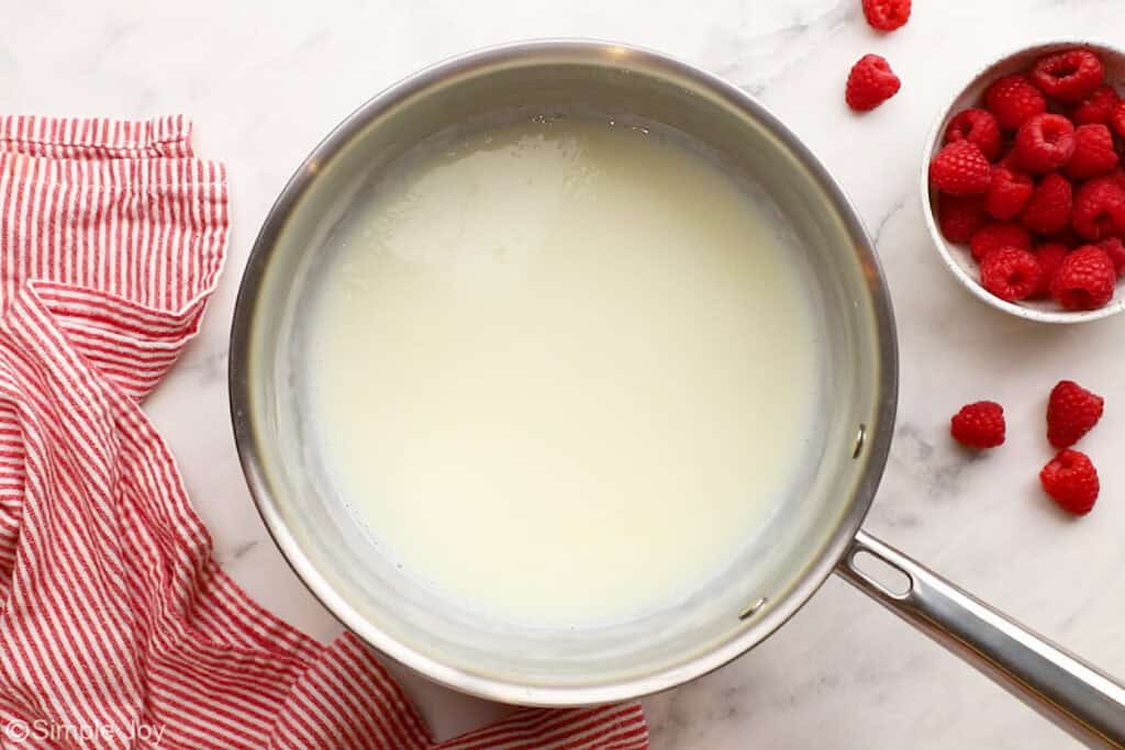 overhead of milk boiling in a saucepan to make homemade vanilla pudding