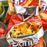 Pinterest graphic for Walking Tacos. Says "the best Walking Tacos simplejoy.com" Image shows a bag of walking tacos topped with shredded cheese, shredded lettuce, and taco meat.