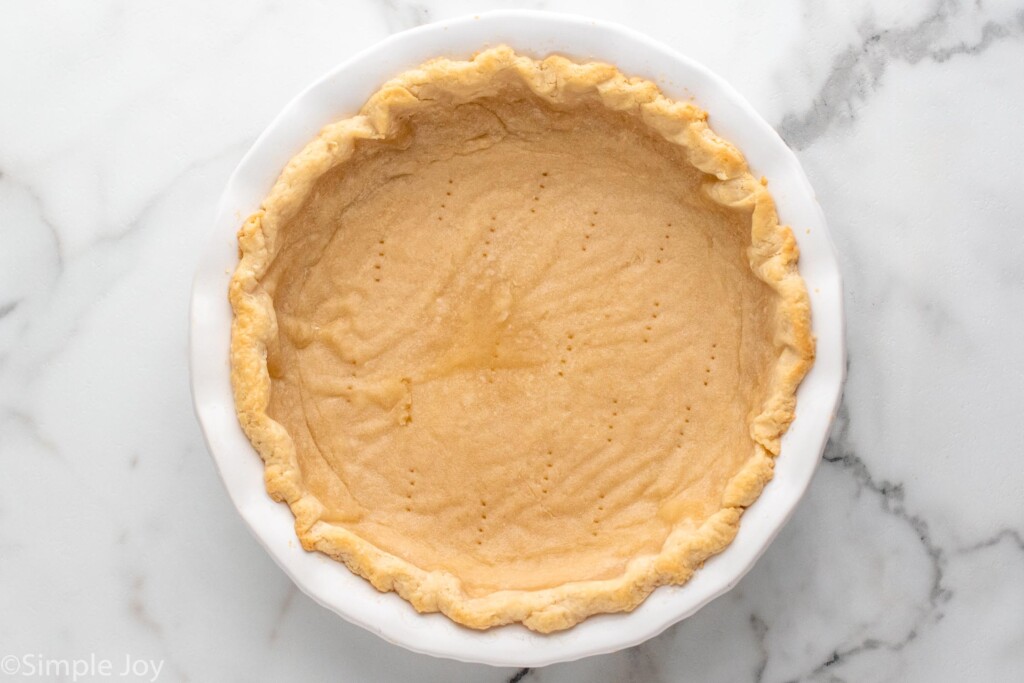 a partially baked pie crust that has been pierced with a fork