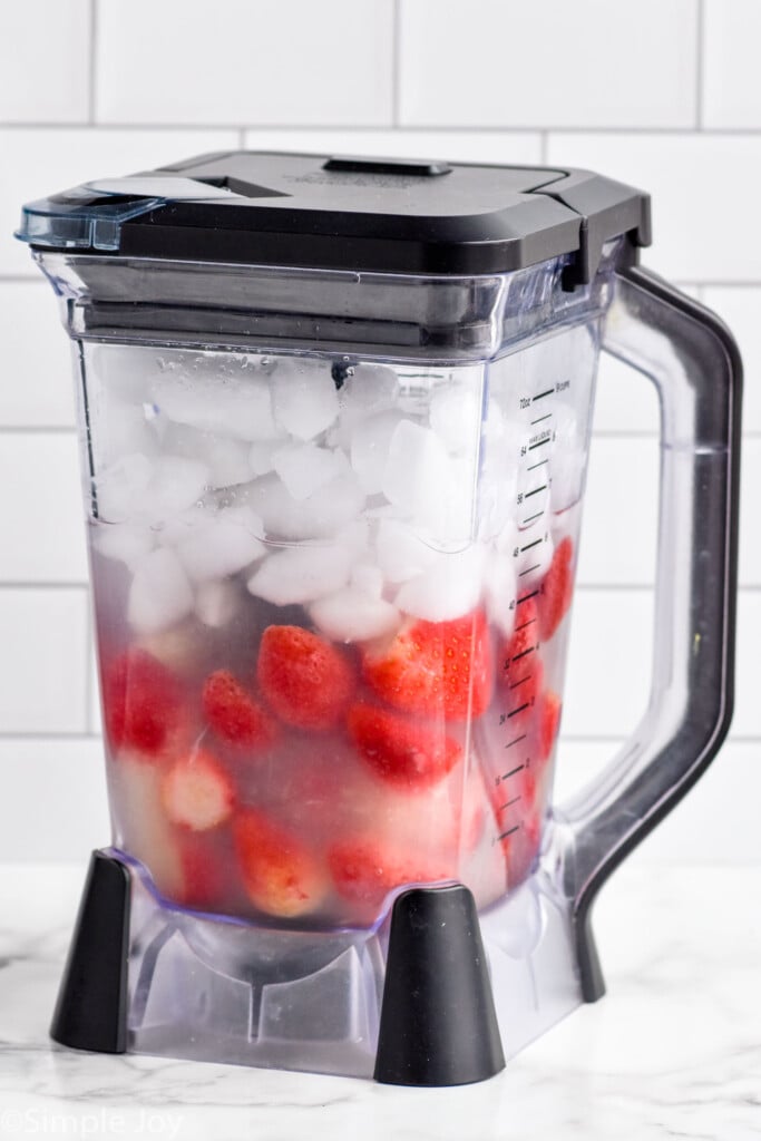 Blender of daiquiri strawberry ingredients and ice