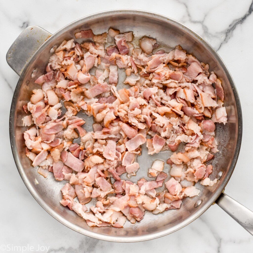 overhead of skillet of diced bacon to make German Potato Salad
