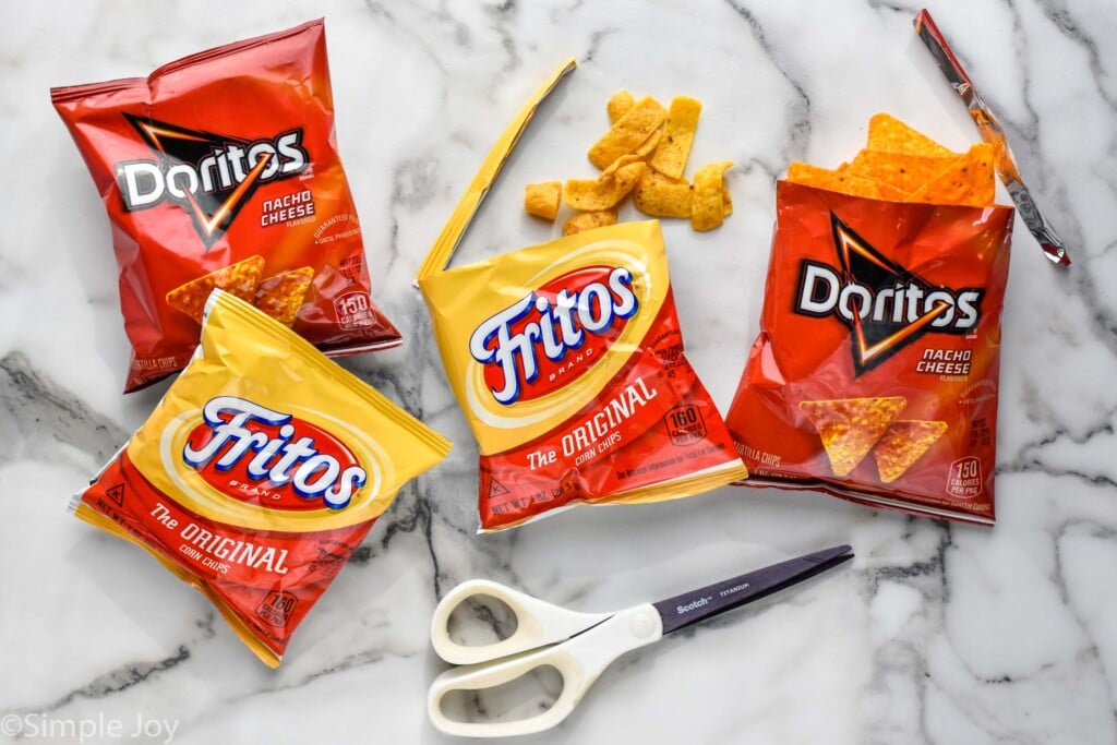 overhead of small bags of doritos and fritos with a scissors for making walking tacos