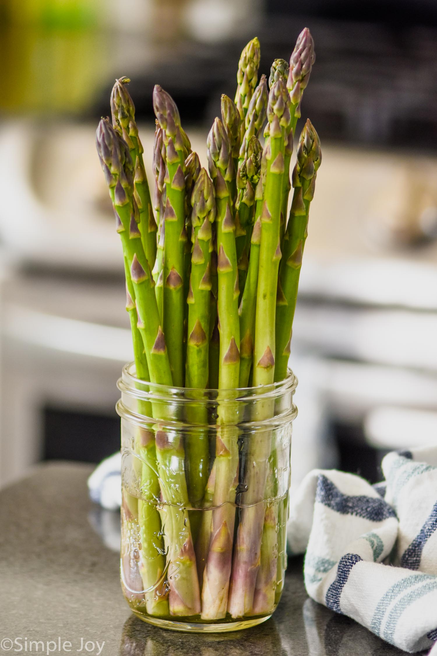 fresh asparagus in a mason jar with water