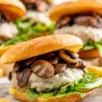 Mushroom Swiss Burger on bun with lettuce. Mushroom Swiss Burgers sitting behind